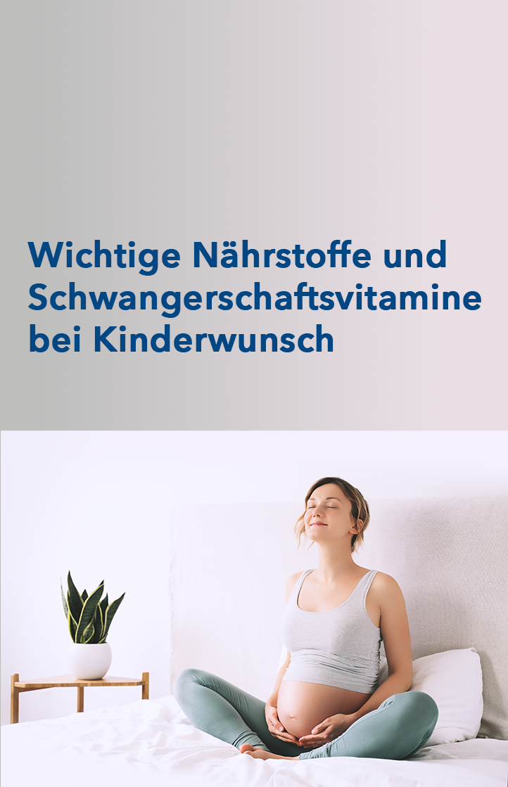 Eine schwangere Frau sitzt im Schneidersitz auf dem Bett und hält sich ihren Bauch.