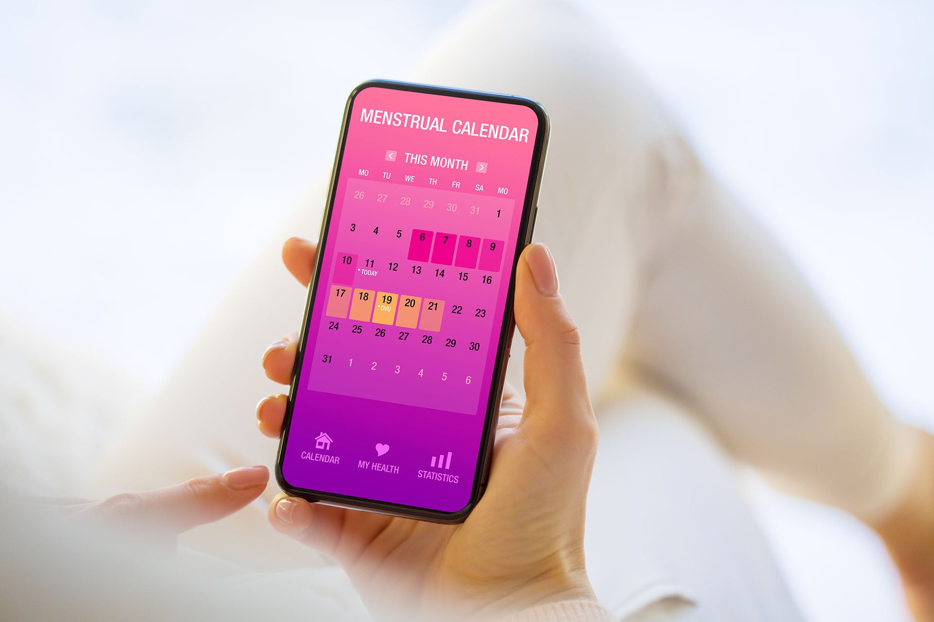 Smartphone in der Hand mit Fruchtbarkeitskalender angezeigt