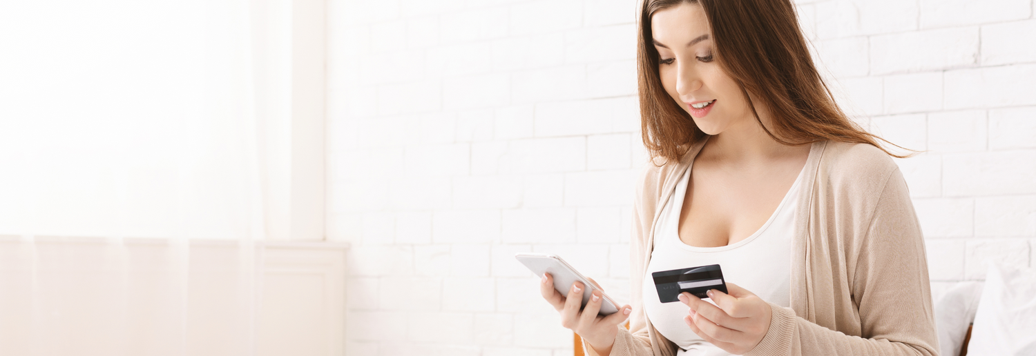 Eine schwangere Frau kauft auf ihrem Handy Produkte mit ihrer Kredikarte