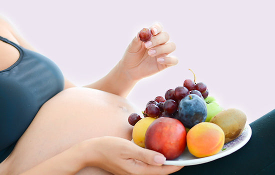 Schwangere isst einen Obsttteller