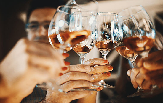Mehrere Weingläser werden angestoßen